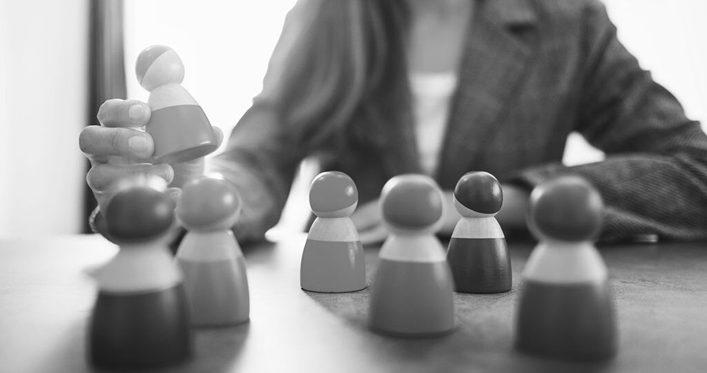 Businesswoman leader choosing wooden people figure from a group