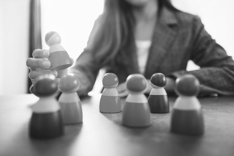 Businesswoman leader choosing wooden people figure from a group