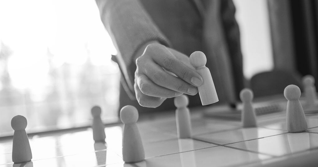 Businesswoman leader choosing wooden people from a group of empl