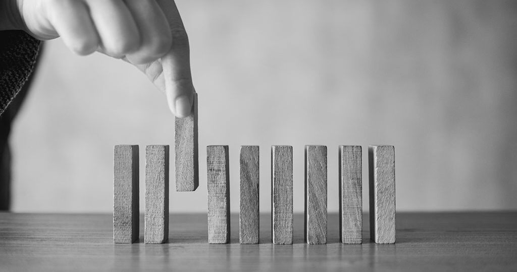 Closeup image of a hand putting wooden block in a row on the tab