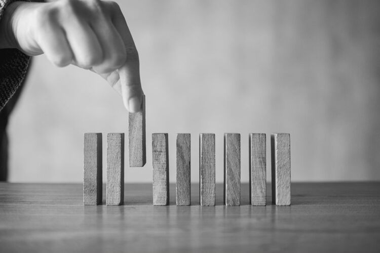 Closeup image of a hand putting wooden block in a row on the tab